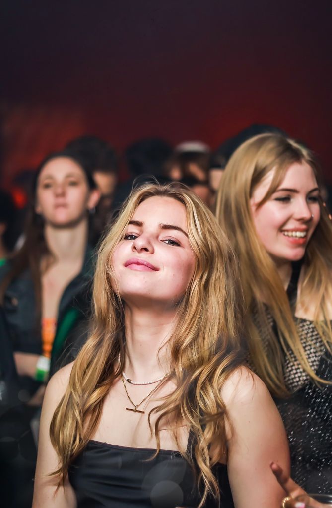 Smiling young adults enjoying themselves at a lively indoor party.